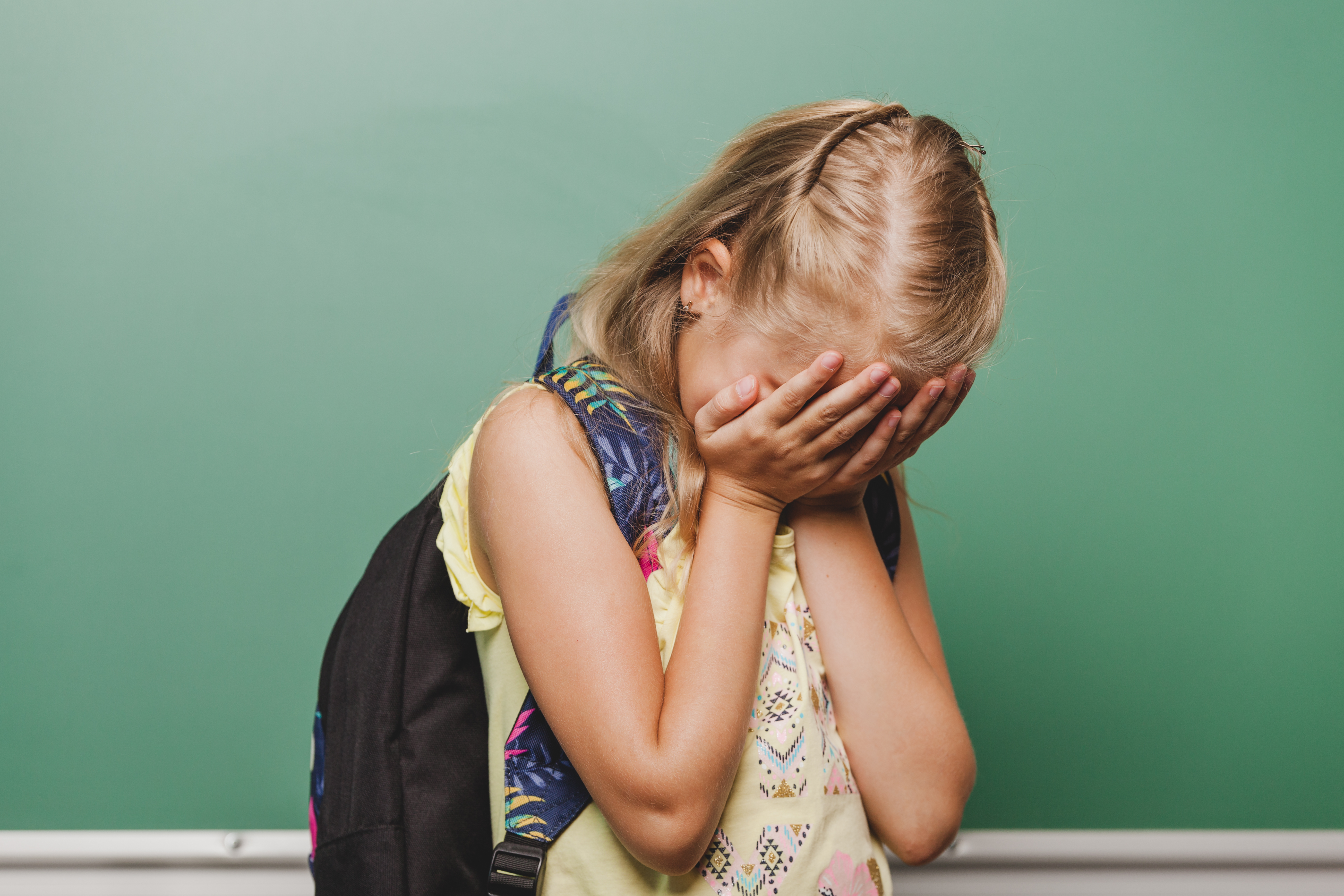superproteção e negligência fatores que levam as crianças a fazerem bullying - criança com a mão no rosto