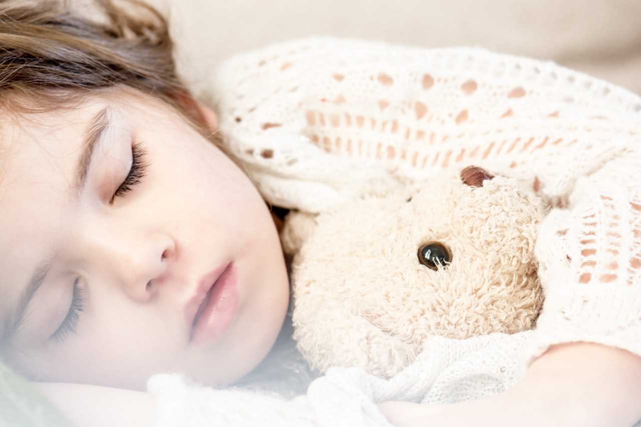 boas práticas para o sono das crianças - menina dormindo com ursinho