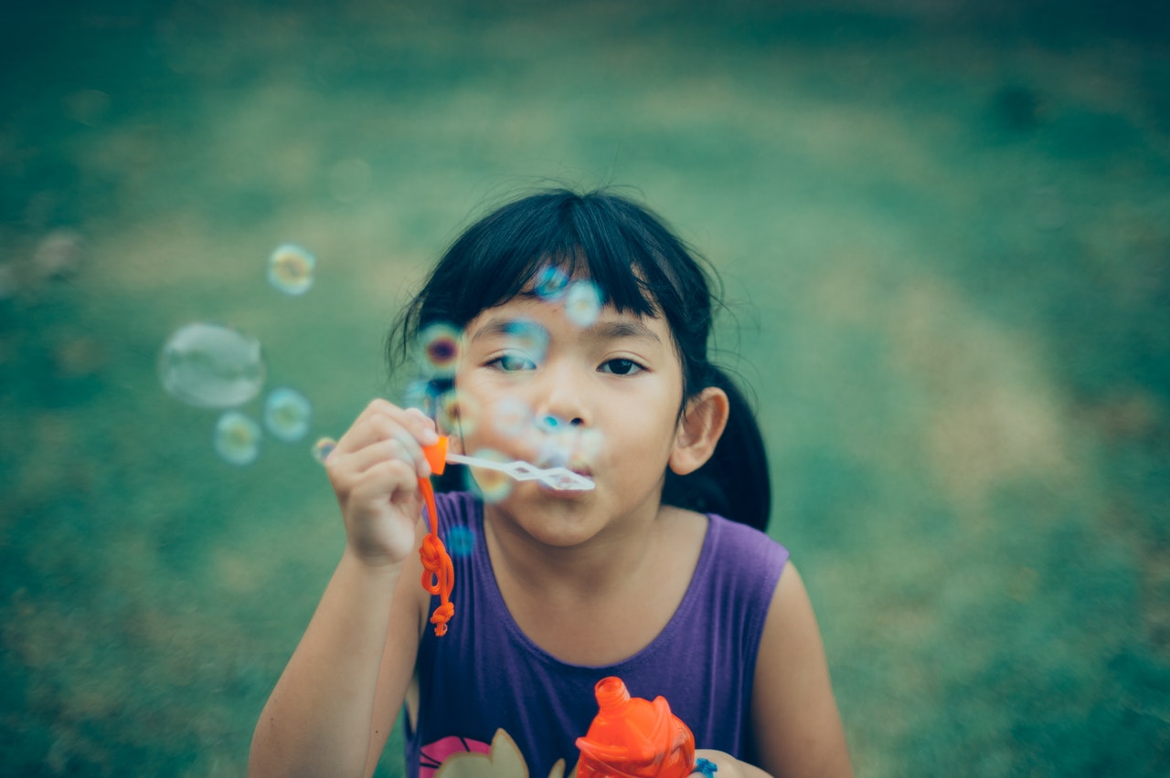 menina fazendo bolhas de sabão