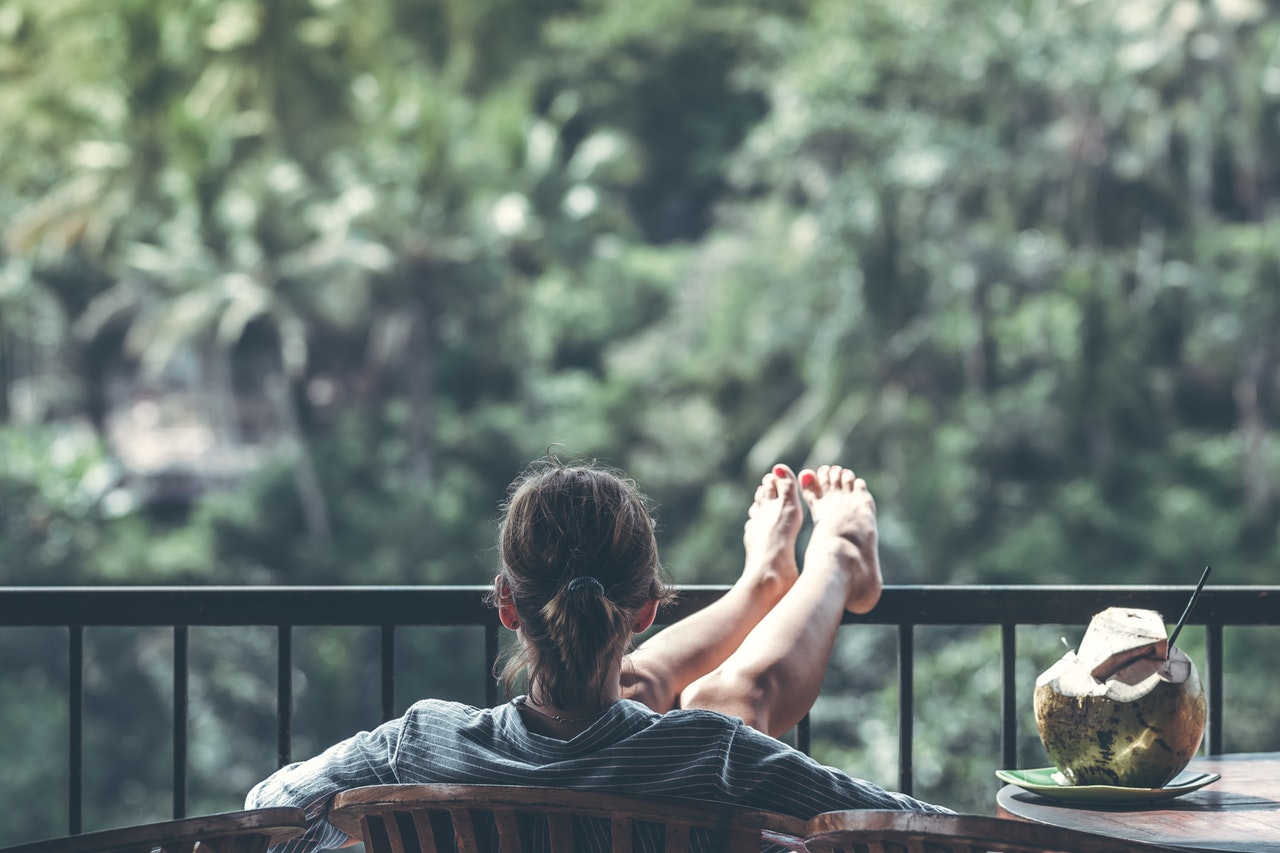 woman sitting on brown wooden chair beside coconut 1230665